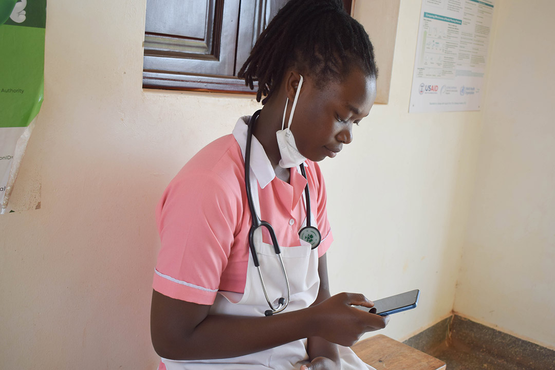 A female health worker in Mukono Uganda trying to access her mobile money account (Photo/Courtesy)